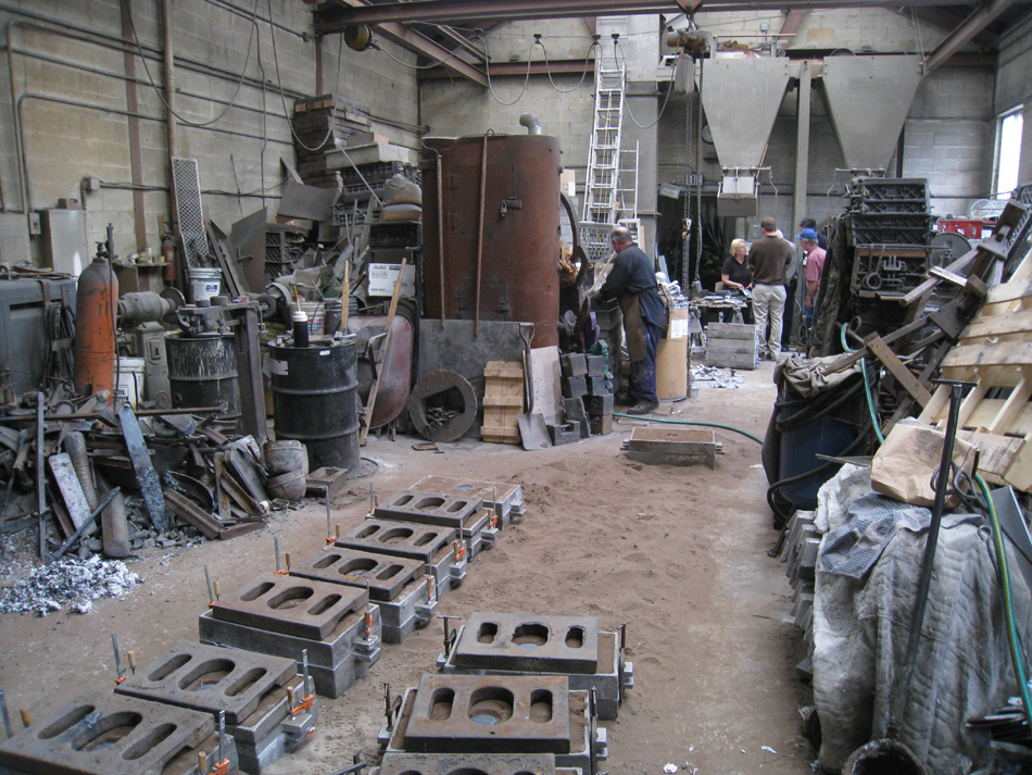 Fence -- Swiss Foundry -- view of foundry with newly poured molds in front.