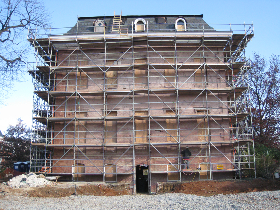 Elevation--East side after paint removal.  Worker preparing mortar joints for repointing